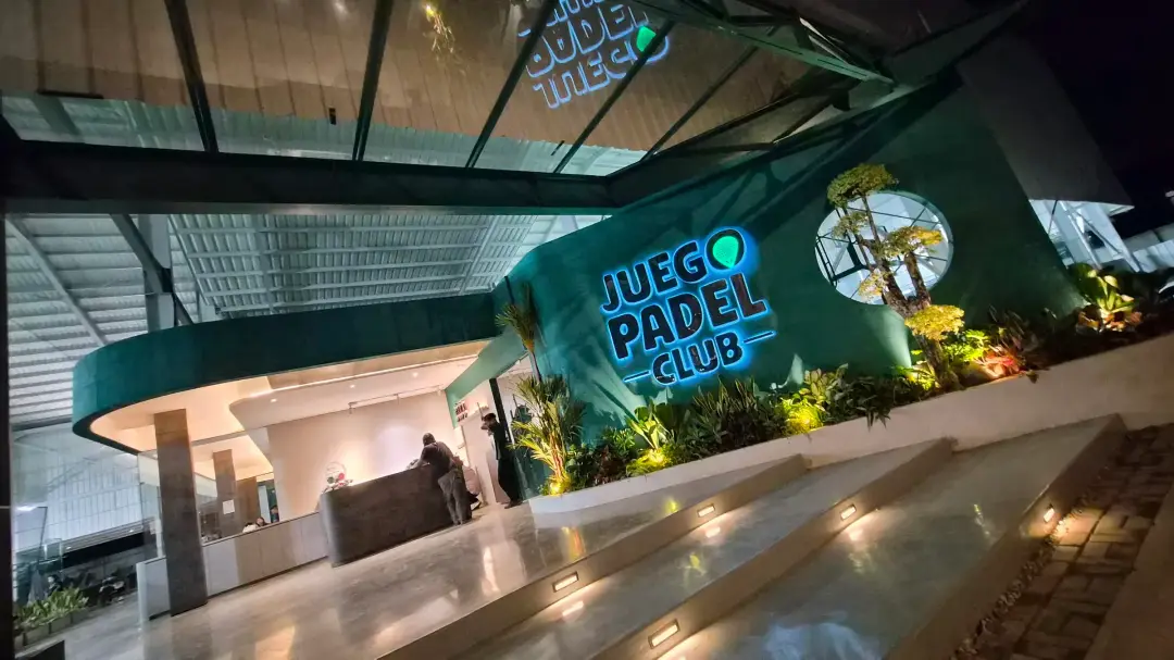 The lit Juego Padel Club entrance at night